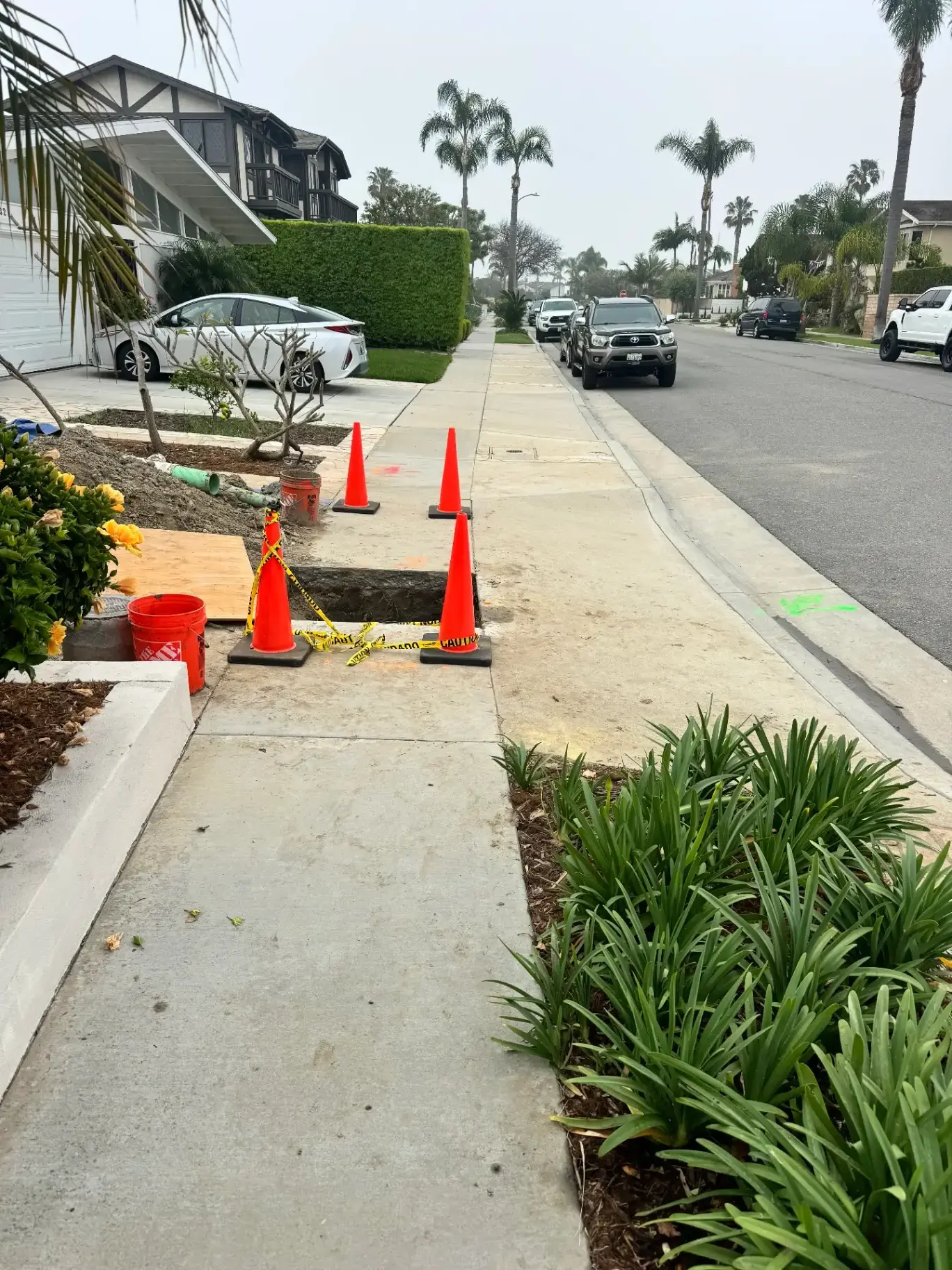 Curbside sewer lateral excavation with safety cones in Orange County